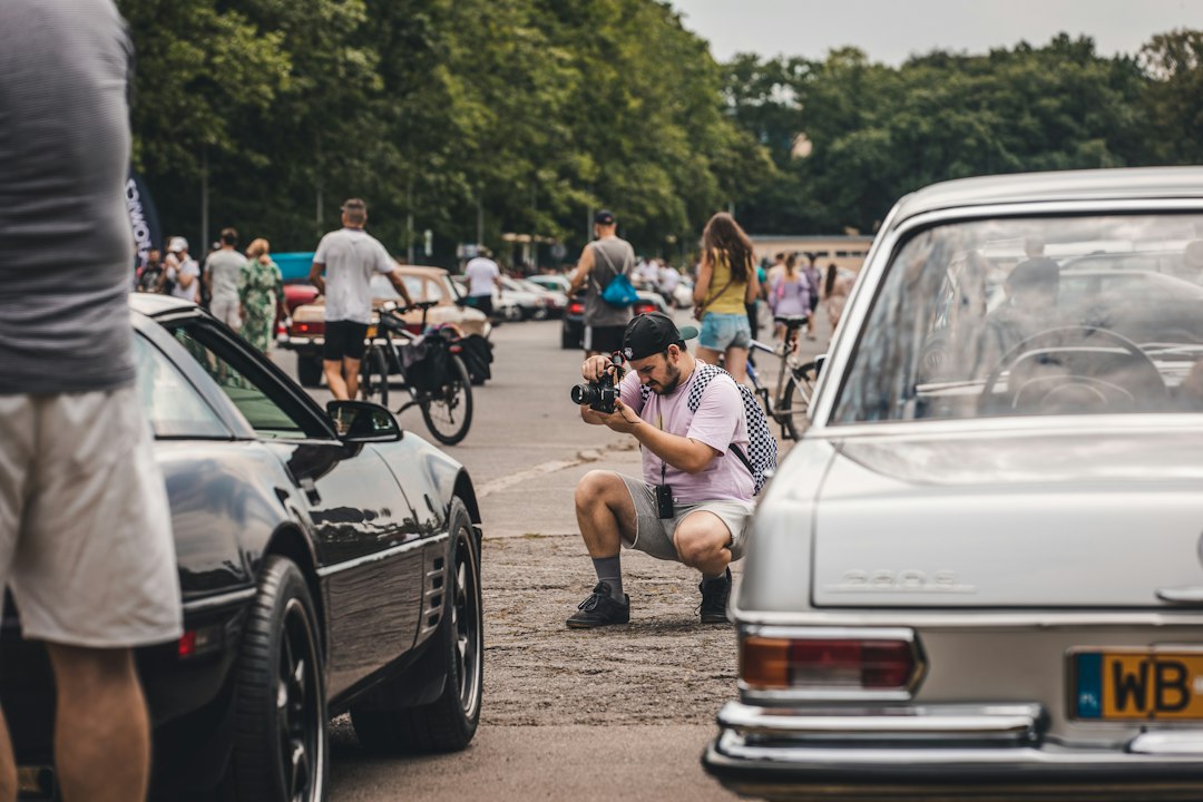 Cinematographer filming vintage cars at an outdoor car event
